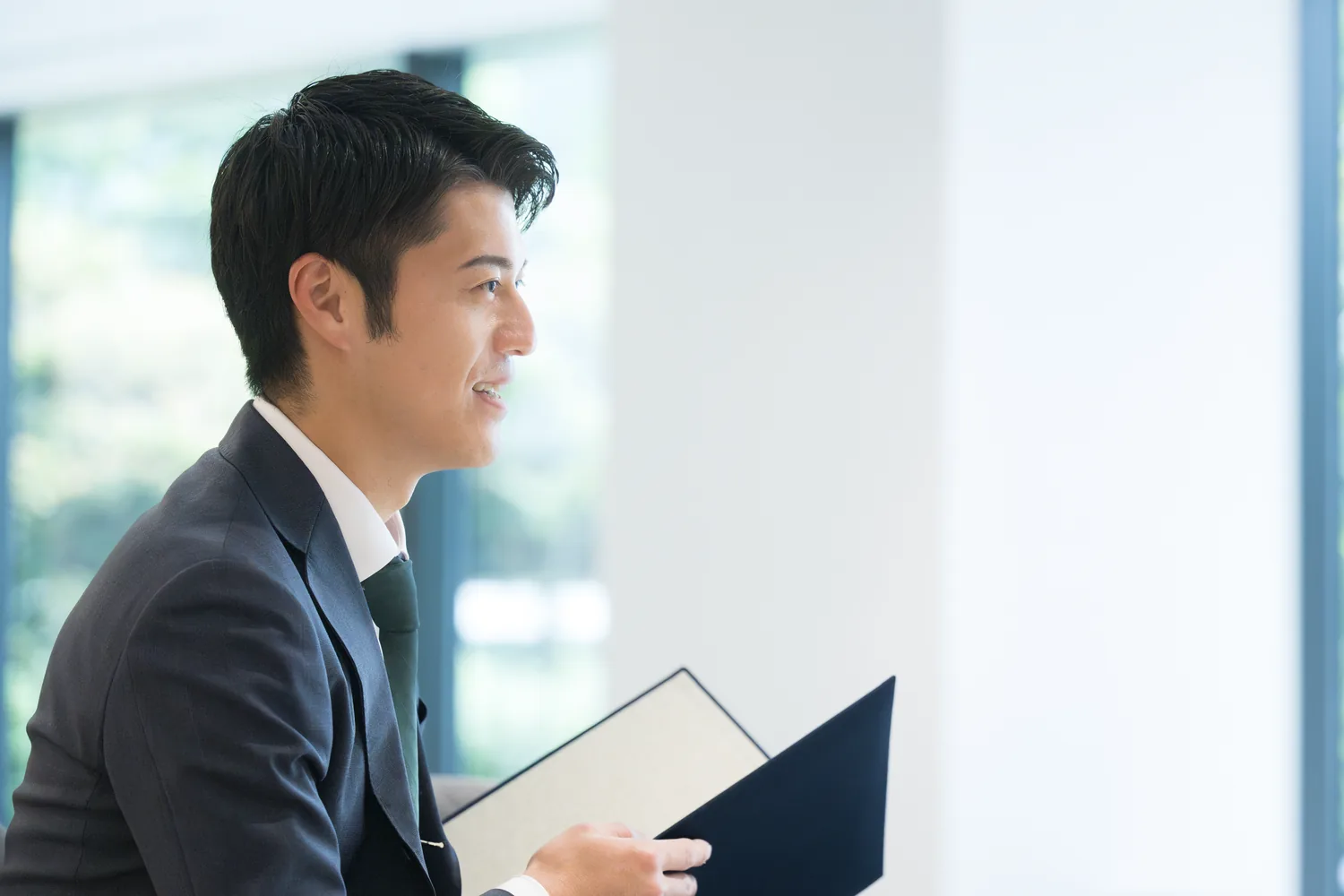 資料を手に話を聞く男性